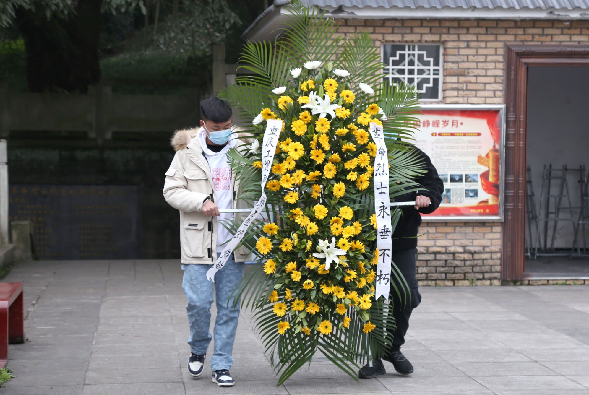 (学生代表向烈士纪念塔献花篮)